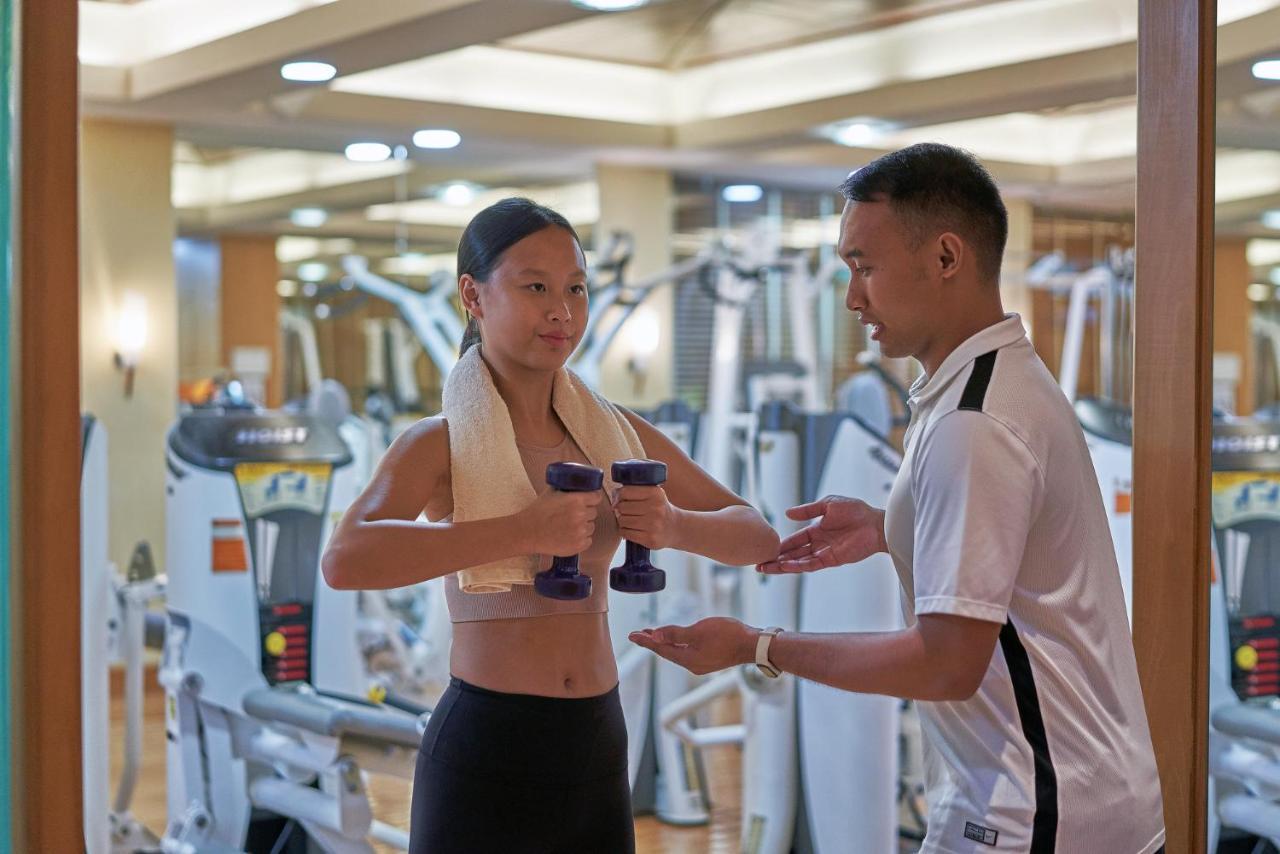 Artyzen Grand Lapa Macau Hotel Eksteriør billede A personal trainer assisting a woman with a dumbbell workout